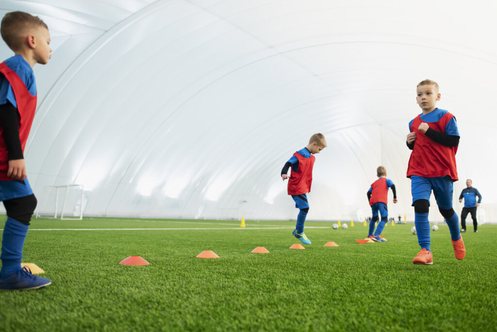 dzieci trenujące szybkość na boisku piłkarskim